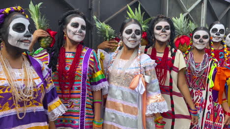 a group of girls wearing traditional outfits celebrate the mexican holiday day of the dead at the annual parade in mexico city. dia de muertos is a national holiday in mexico for remembering the dead