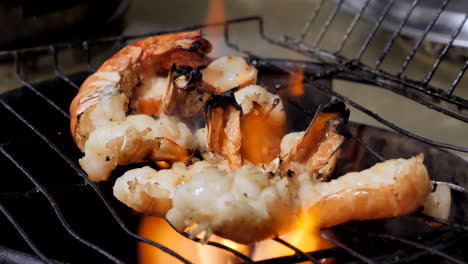 close up grilling freshwater prawn over high heat and framing in the kitchen