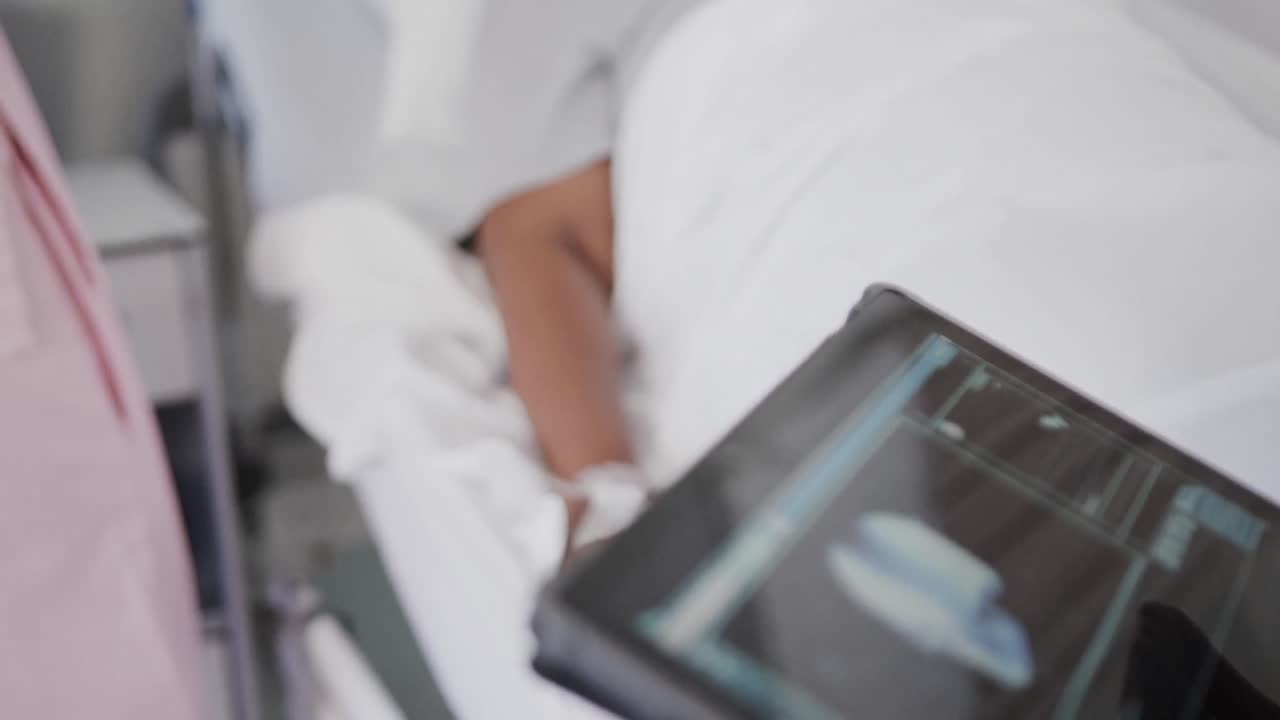 enfermera diversa, médico con tableta y paciente de edad avanzada en goteo en la cama, cámara lenta