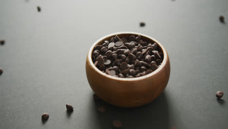 video de un cuenco de madera de trozos de chocolate sobre un fondo gris