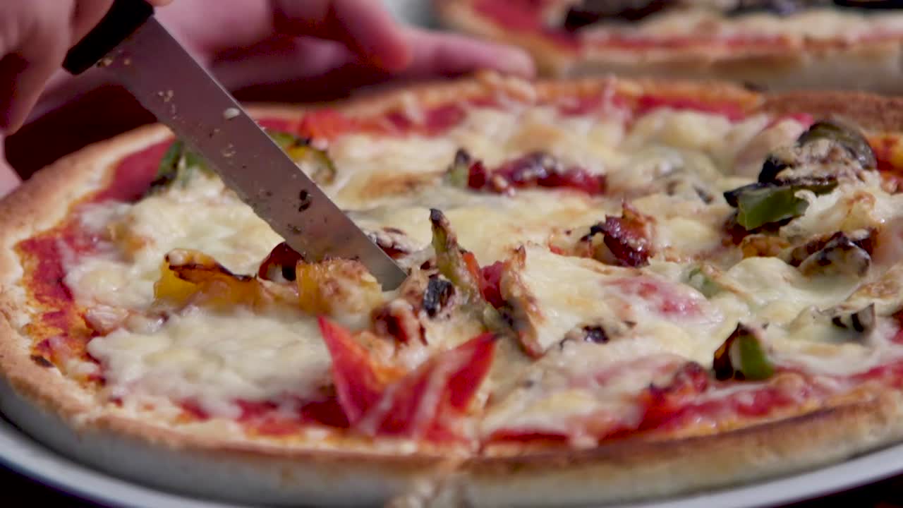 en lækker pizza, der bliver skåret i skiver