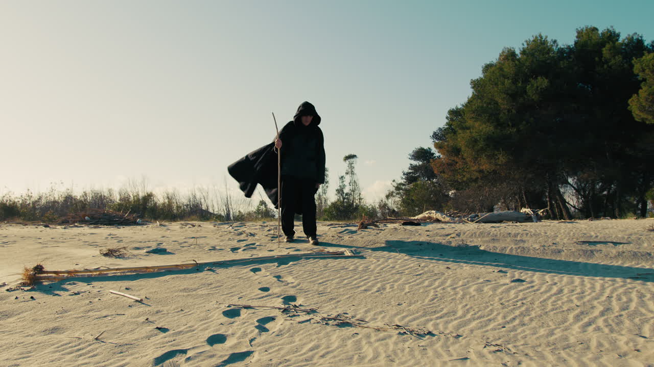 Elderly Sorcerer on the Beach with the Wind Moving His Cloak