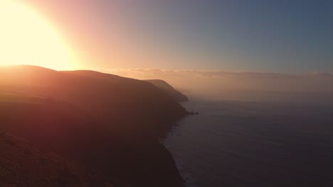 bright sun flare at sunset of exmoor devon coastline of bristol channel ocean sea with beautiful colors and different beaches along coast. aerial drone natural environment footage 4k.