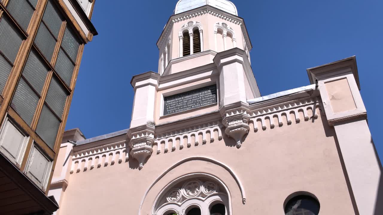 Movimento de câmera inclinando para cima revelando a fachada da Igreja da Dormição da Mãe de Deus em Brașov, Romênia