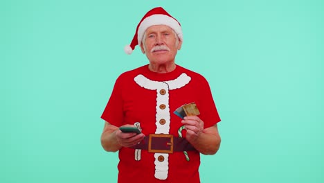 christmas grandfather using credit bank card smartphone while transferring money shopping online