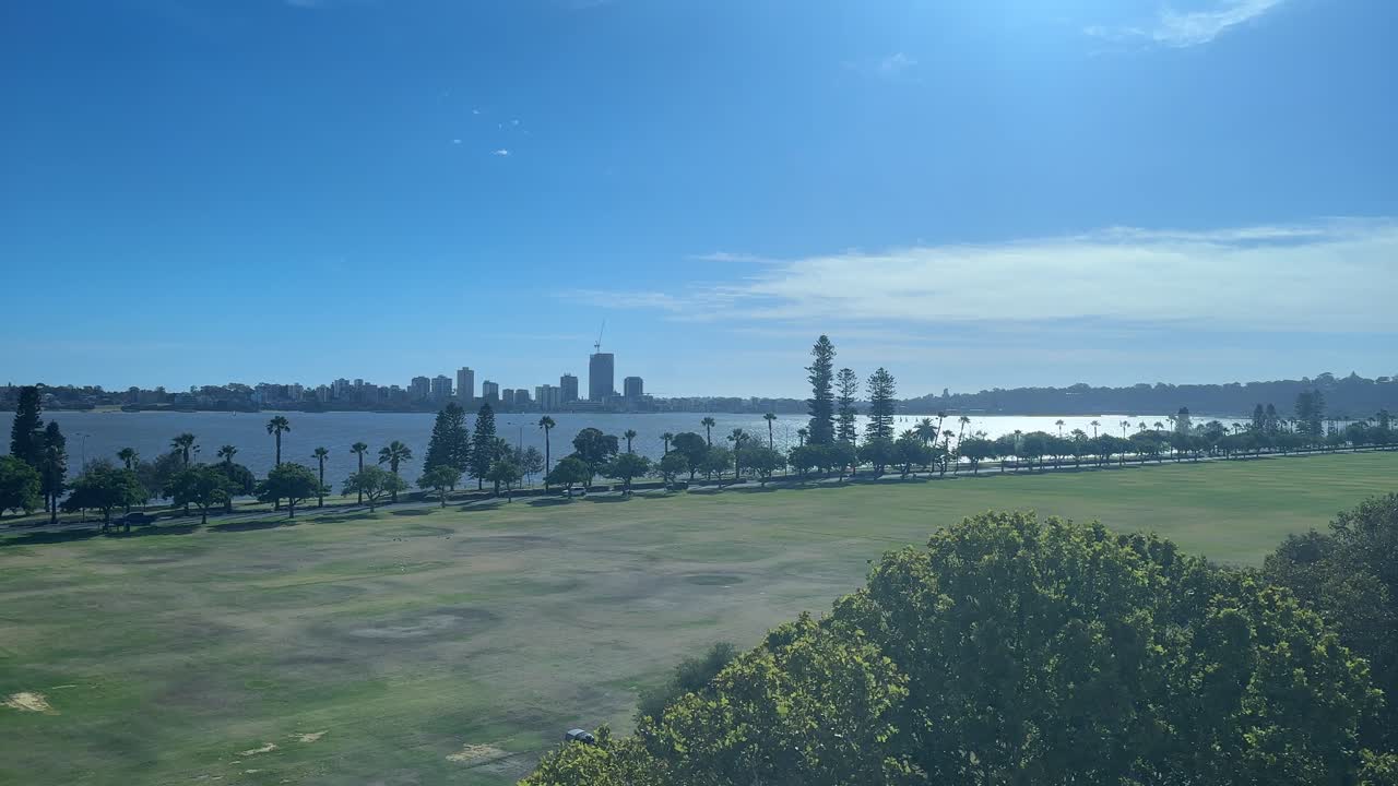 웨스턴 오스트레일리아의 퍼스 (perth) 에 있는 랭글리 파크 (langley park) 와 리버사이드 (riverside) 포어쇼어 (foreshore) 위의 풍경, 스완 강 (swan river) 에 있는 푸른 하늘과 광활한 초록 잔디이 있는 오피스 빌딩에서