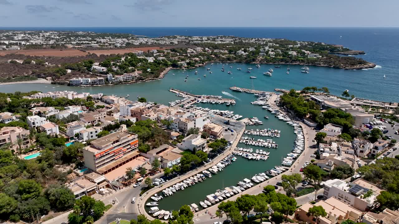 Beautiful Spanish harbor town during summer with crystal clear water and boats on Mallorca