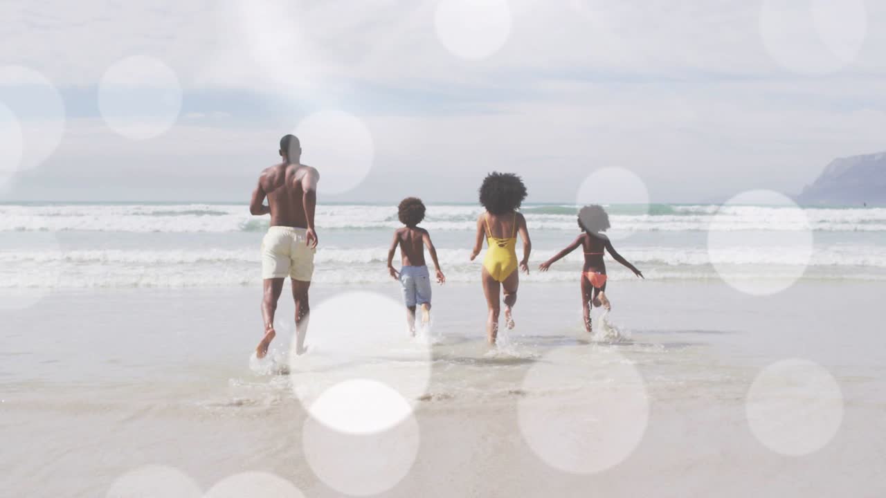 Family running toward waves on spotting surf, splashing for family fun travel with bokeh overlay