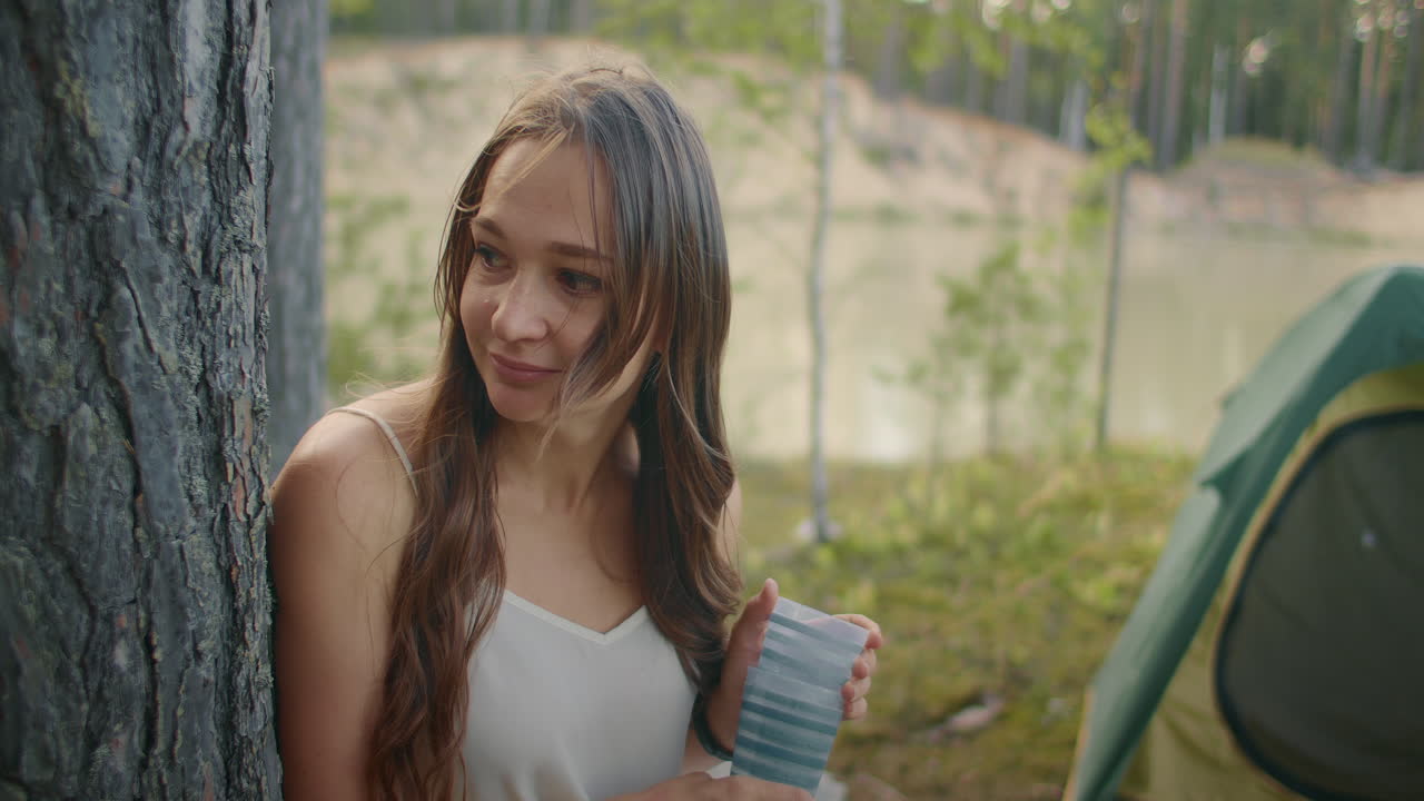 숲에서 캠핑하는 성인 여성의 초상화 기쁜 여인이 가족이나 친구들과 함께 자연에서 휴식을 취하고 있습니다.