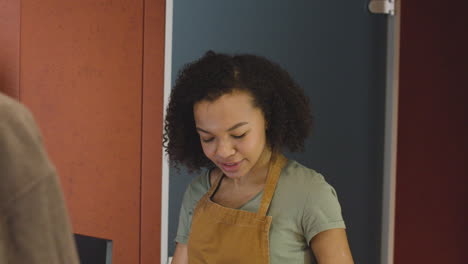 smiling woman selling movie tickets at the cinema