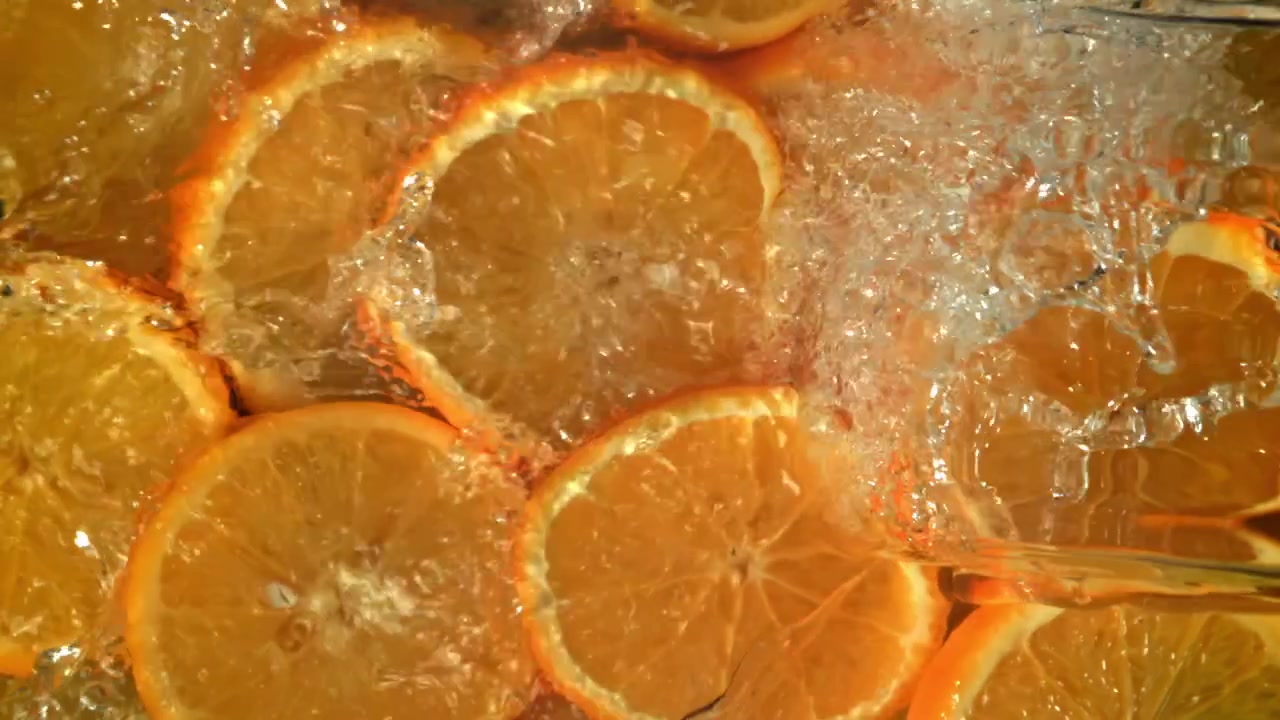 Acqua rinfrescante che schizza su vivaci fette d'arancia