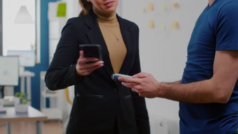 Close-up-of-businesswoman-paying-takeaway-food-lunch-order-with-smartphone-using-POS