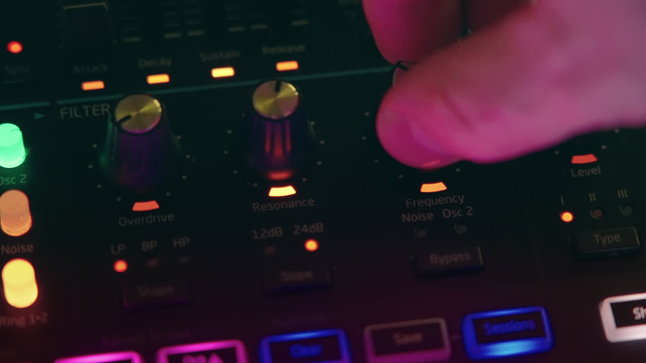 Close-up of Hand Adjusting Knob on Electronic Synthesizer