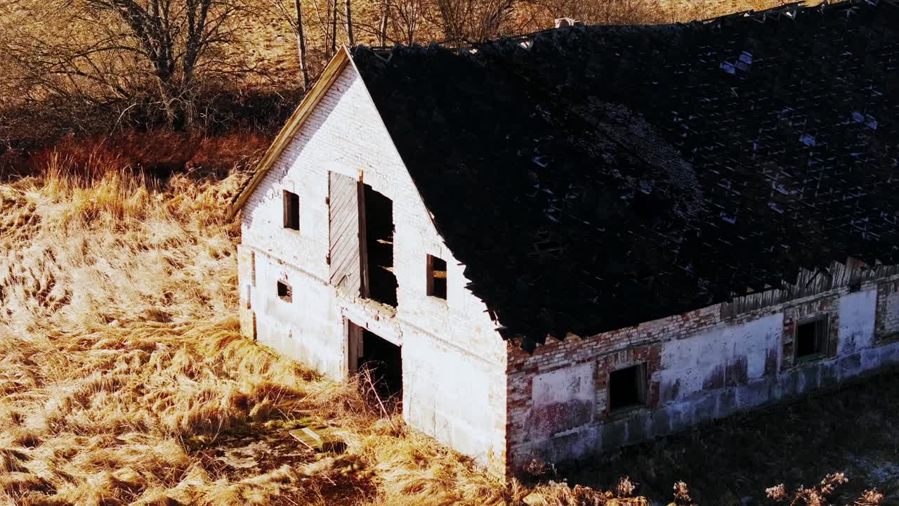 Abandoned farm ruins from Soviet era seen as drone glides low in Latvian fields