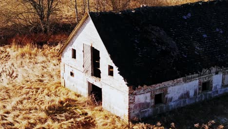 abandoned farm ruins from soviet era seen as drone glides low in latvian fields