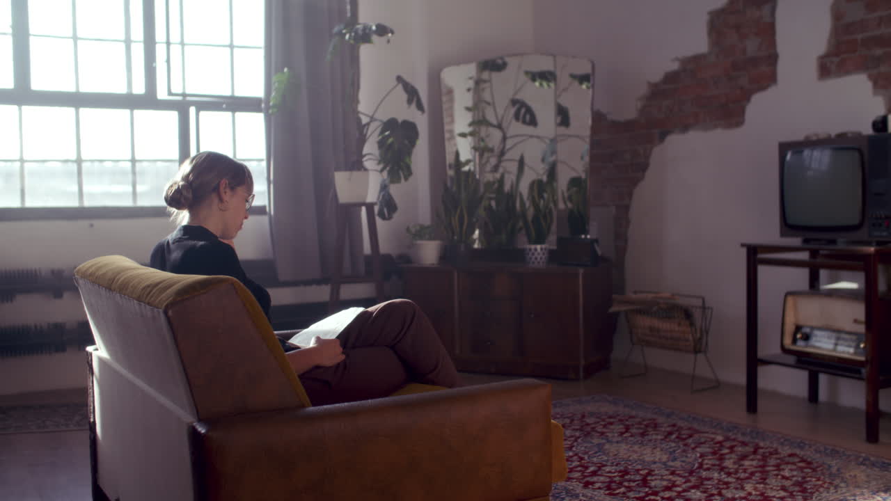 женщина читает в гостиной.