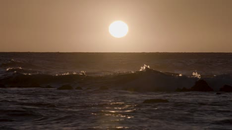 looking out at the ocean waves of hawaii, as the sun begins to go down