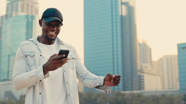 Man celebrating good news on his phone in a city