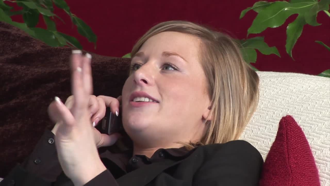 ⁇ 끔하게 옷을 입은 여자 가 전화 를 사용 하고 있다