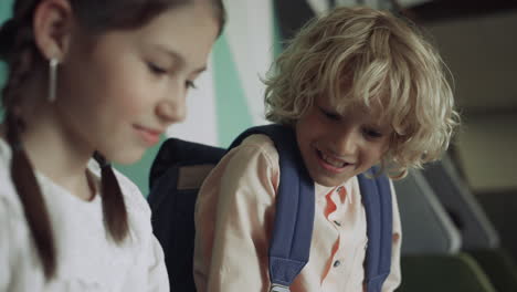 Two-schoolchildren-playing-together-in-school-corridor-close-up.-Kids-have-fun.