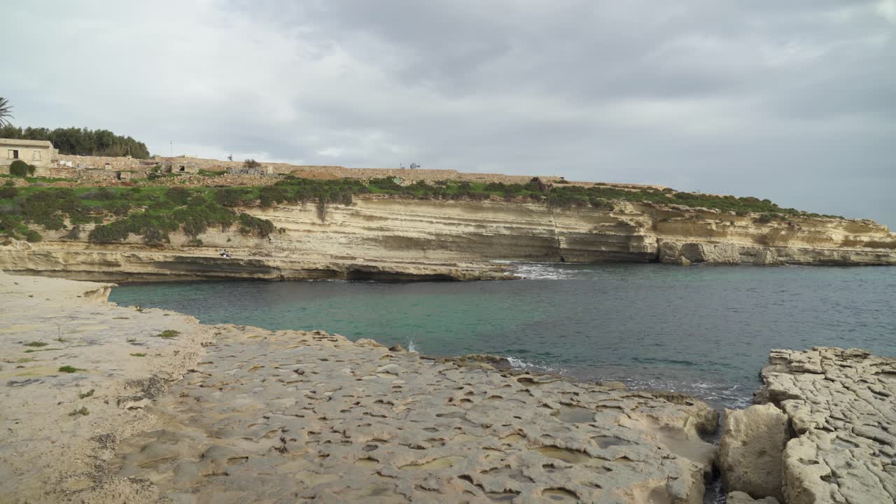 panorama de la larga y remota playa de piedra il-kalanka en malta