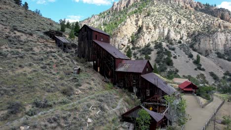 Bayhorse-Mine-and-ghost-town-in-Idaho-Mountains--aerial-view-of-mill-with-mountain-peaks