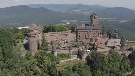 circulating aerial shot showing the full side of a renovated medieval castle in the alsace region of france