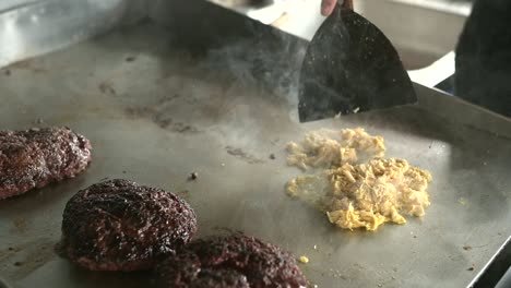 crop chef cooking pulled chicken meat on hot surface