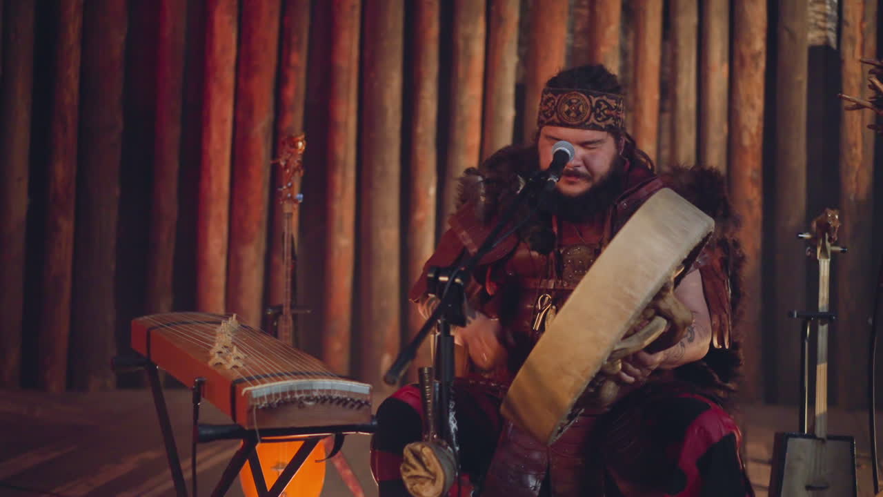 hombre gordo asiático toca tamborín chamánico y canta en la cabina