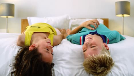 hermanos relajándose en la cama en el dormitorio