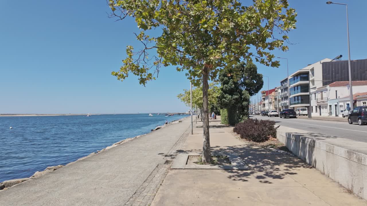 People walking on a sunny day by the Rua do Passeio Alegre waterfront in Porto, Portugal