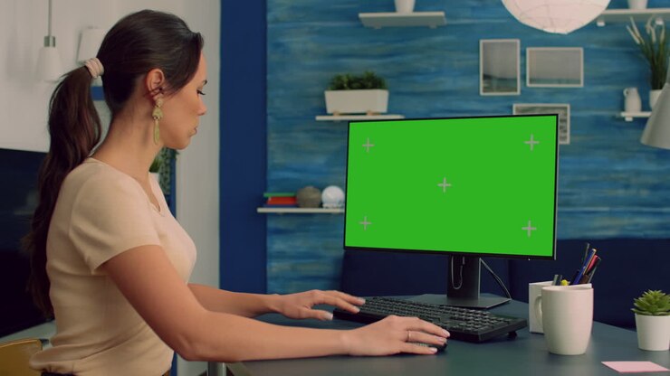 Kaukasisk kvinde arbejder ved sit skrivebord på en personlig computer.
