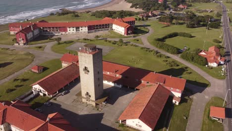 aerial orbit shot of old hotel resort with ocean view and sandy beach during sunny day- chapadmalal,argentina