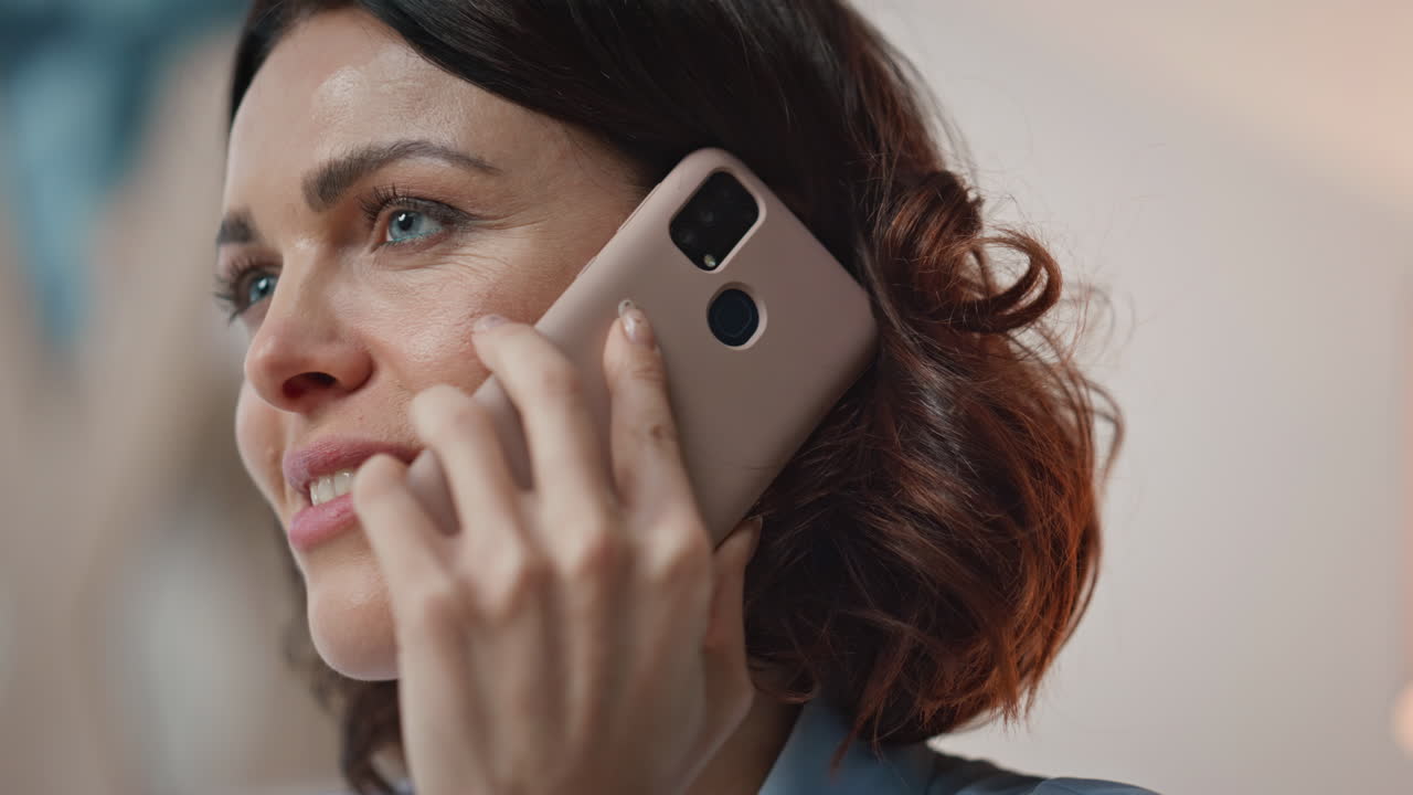 Zbliżenie kobiety rozmawiającej przez telefon komórkowy w biurze. Portret bizneswoman wykonującej połączenie.