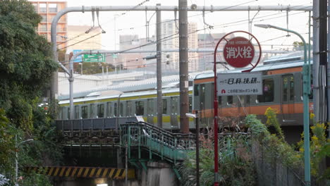 two subway trains passing by the railway at train station in tokyo, japan during daytime