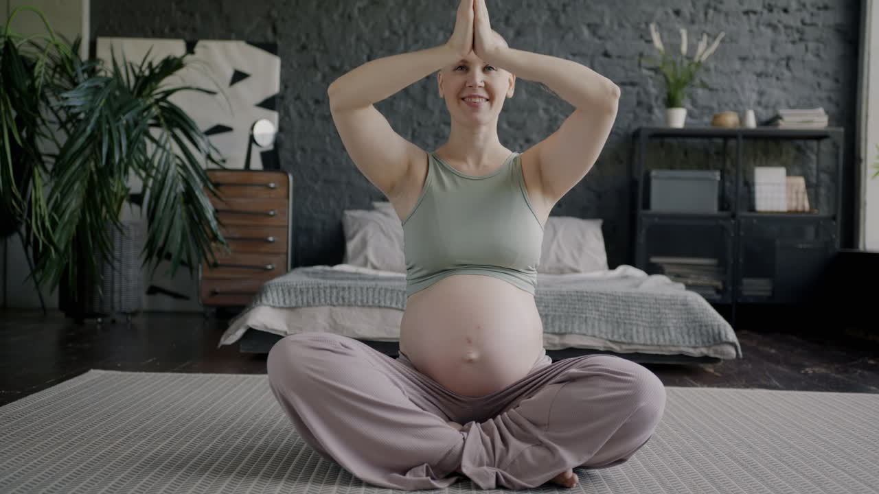 mujer embarazada haciendo yoga en casa