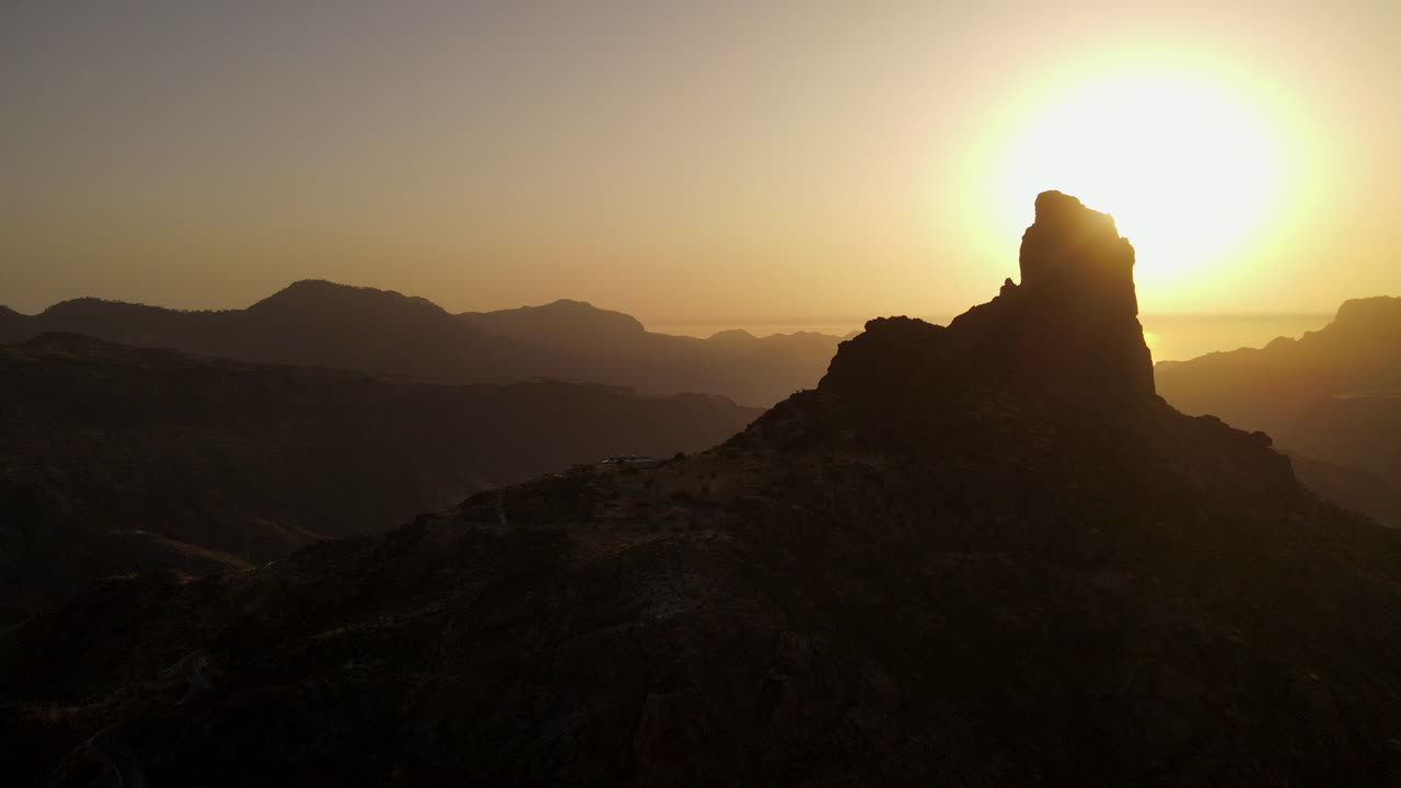 Aerial  circle view of Roque Nublo; volcanic rock in caldera of Tejeda, with suggestive setting sun. Gran Canaria, Canary Islands, Spain. Slow Motion