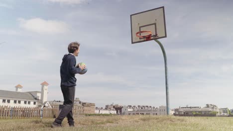 Macho-Adulto-Jugando-Baloncesto-Solo-En-La-Cancha-Al-Aire-Libre-Durante-El-Día