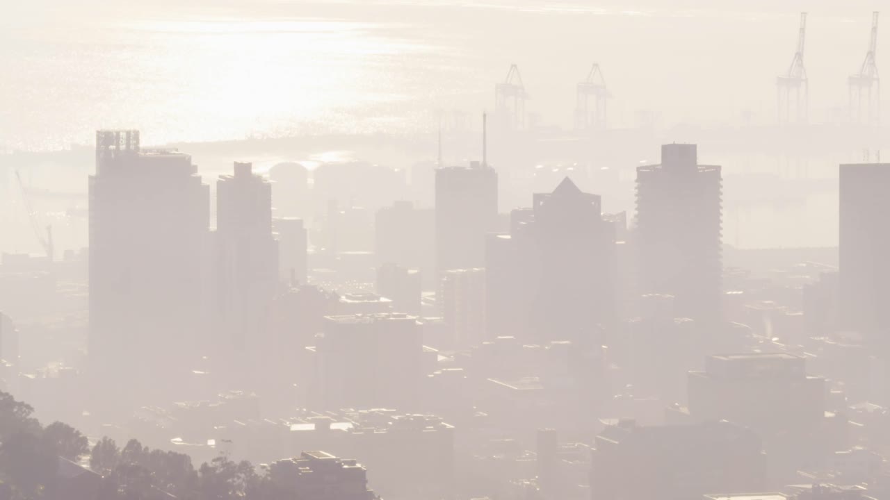 스모그 속 의 여러 현대적 인 사무실 건물 과 항구 와 함께 도시 풍경 의 일반적 인 전망