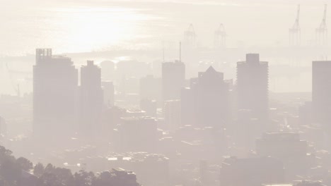 General-view-of-cityscape-with-multiple-modern-office-buildings-and-port-in-smog