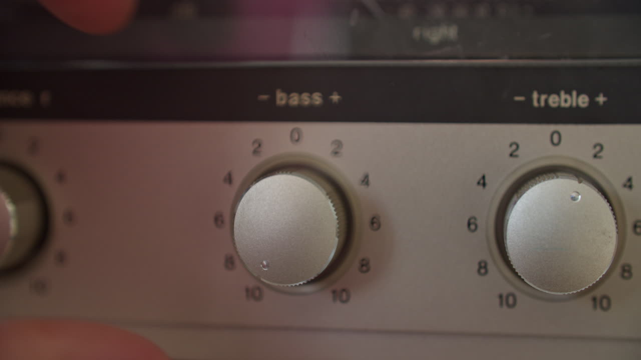 왼손으로 저음 손잡이를 조정하는 극단적인 클로즈업 샷