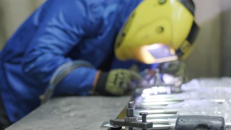 man wearing mask welding in a workshop. metal workers use manual labor. skilled welder. welder is welding the stainless steel pipes in the factory. welder industrial part in factory.