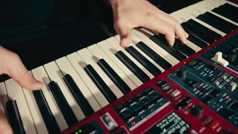 close up of keyboard player hands playing rock music with keyboard at the concert in studio, rehearsal room, macro play on synthesizer.