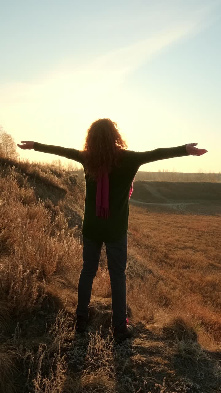 Una mujer disfrutando de la puesta de sol.