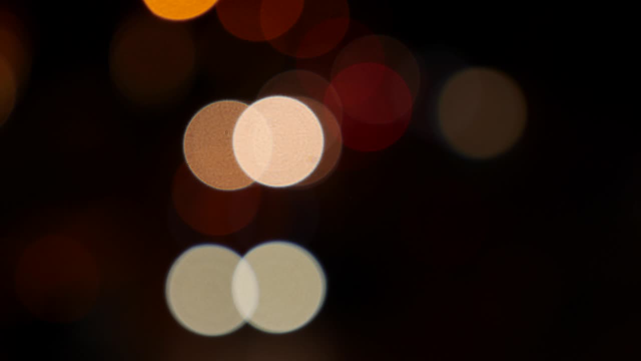 hermoso bokeh brillante en el fondo oscuro borroso por la noche. el redondo bokeh colorido brilla de las luces de los coches en la calle de la ciudad. fuera de foco con borroso. luces de la ciudad sin enfoque. bokeh de tráfico. concepto abstracto