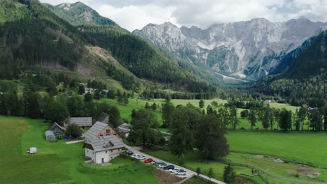 vista aérea del valle alpino con granja rústica en frente, jezersko, eslovenia, alpes europeos, paisaje montañoso escénico