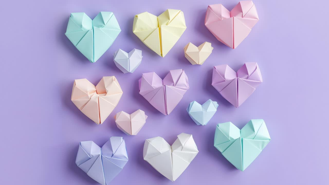 corazones de origami coloridos sobre un fondo púrpura