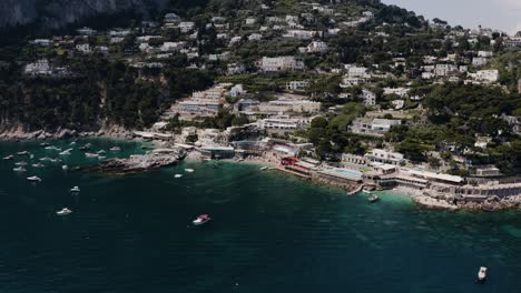 Vista-Aérea-De-Capri,-Las-Tentadoras-Aguas-De-Italia-Con-Complejos-Turísticos-A-Lo-Largo-De-La-Costa.