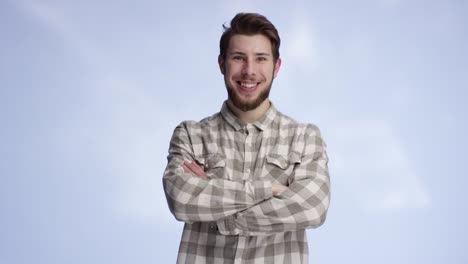 young and handsome man smiling and crossing his arms resolutely