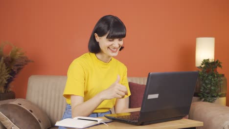 mujer mirando la computadora portátil haciendo un gesto positivo.